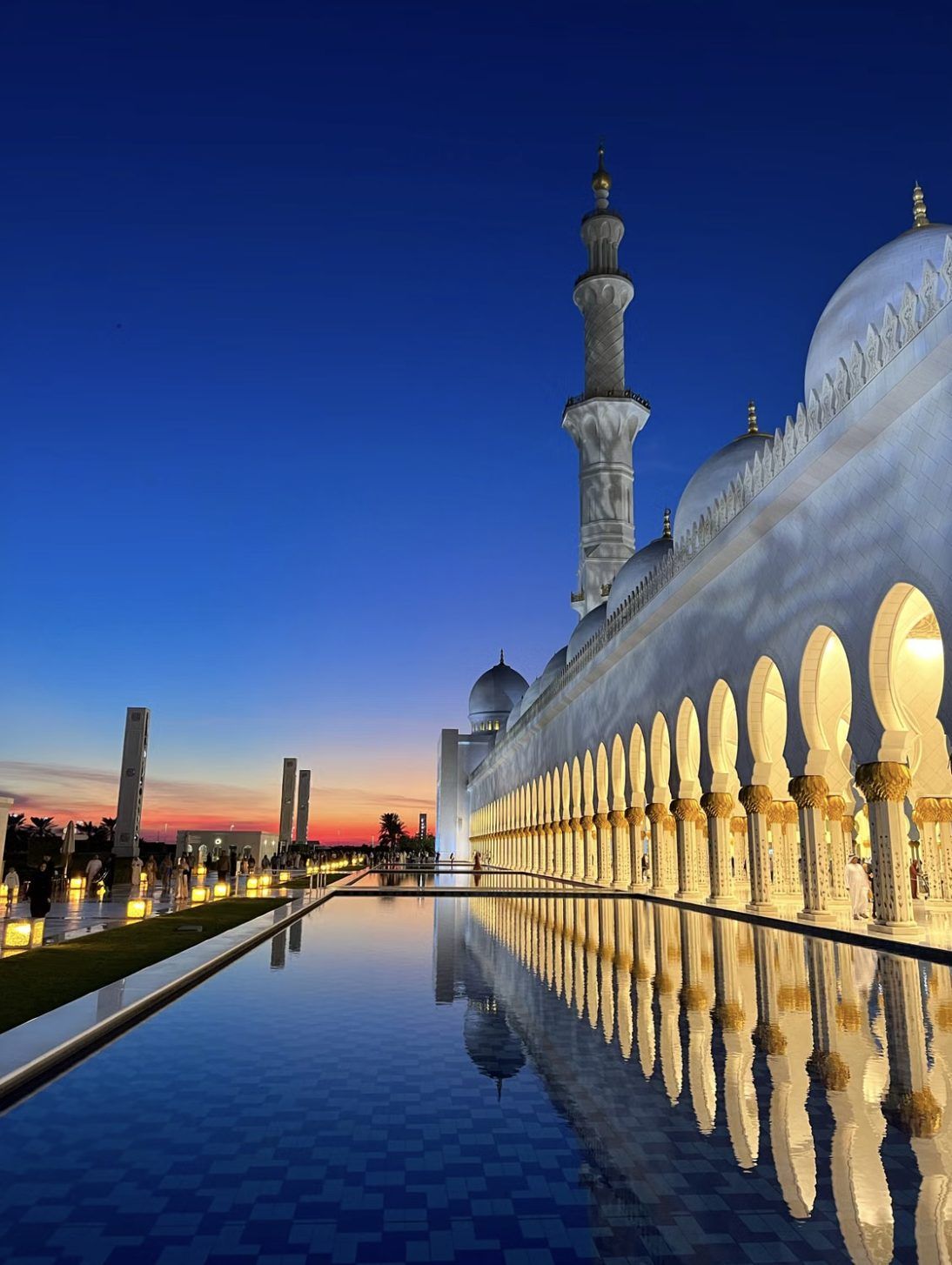 Sheikh Zayed Grand Mosque in Abu Dhabi at dusk, reflected in the courtyard pool